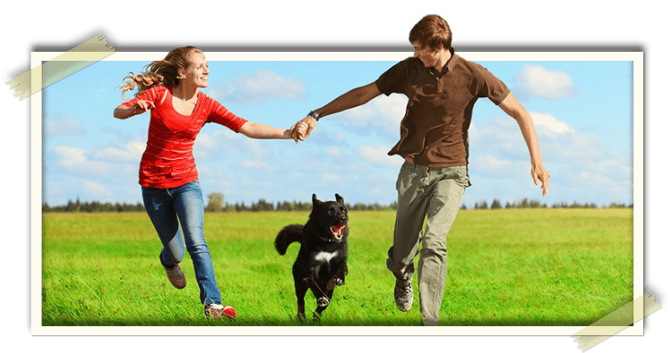 Man and woman running with their dog